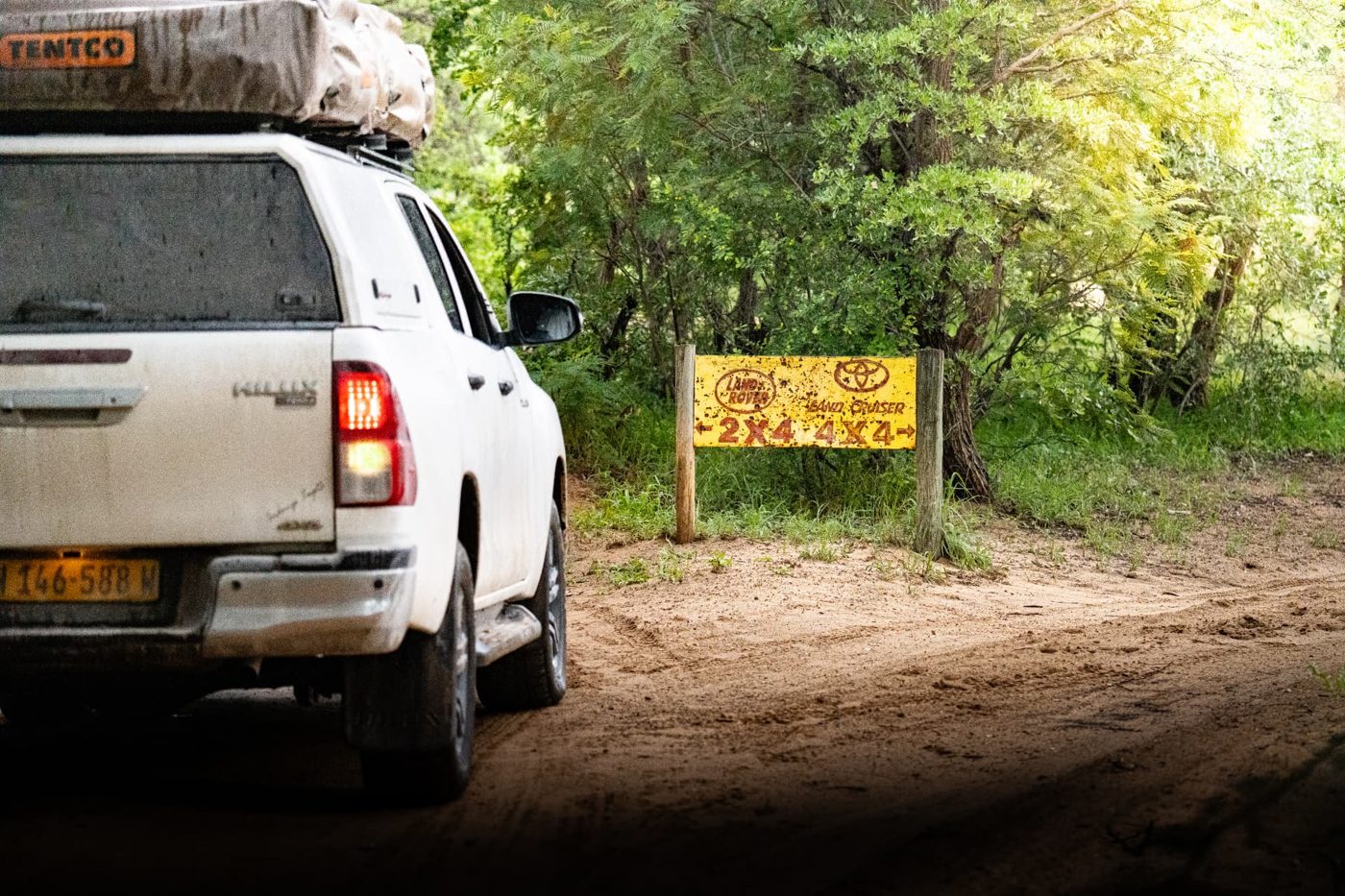 Hilux 4x4 at a 2x4 / 4x4 track sign on a sandy Namibian bush road