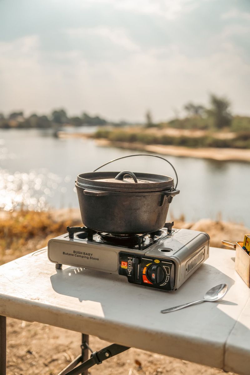 Camping gas stove and potjie pot set up beside a river in Namibia