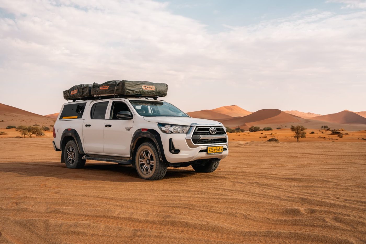 White Toyota Hilux Raider 4x4 parked on the sand near the Sossusvlei dunes, Namibia