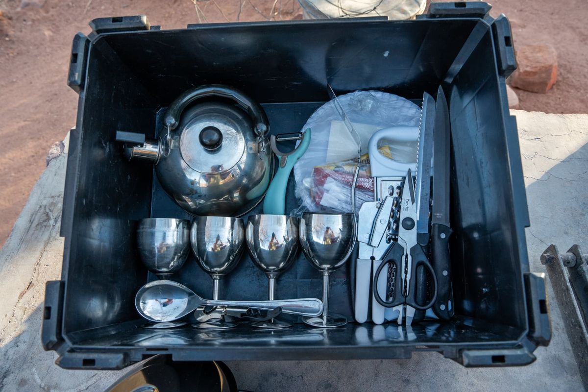 Camping crockery and cutlery box with stainless kettle, wine glasses, knives, peeler and scissors for a Namibia 4x4 rental
