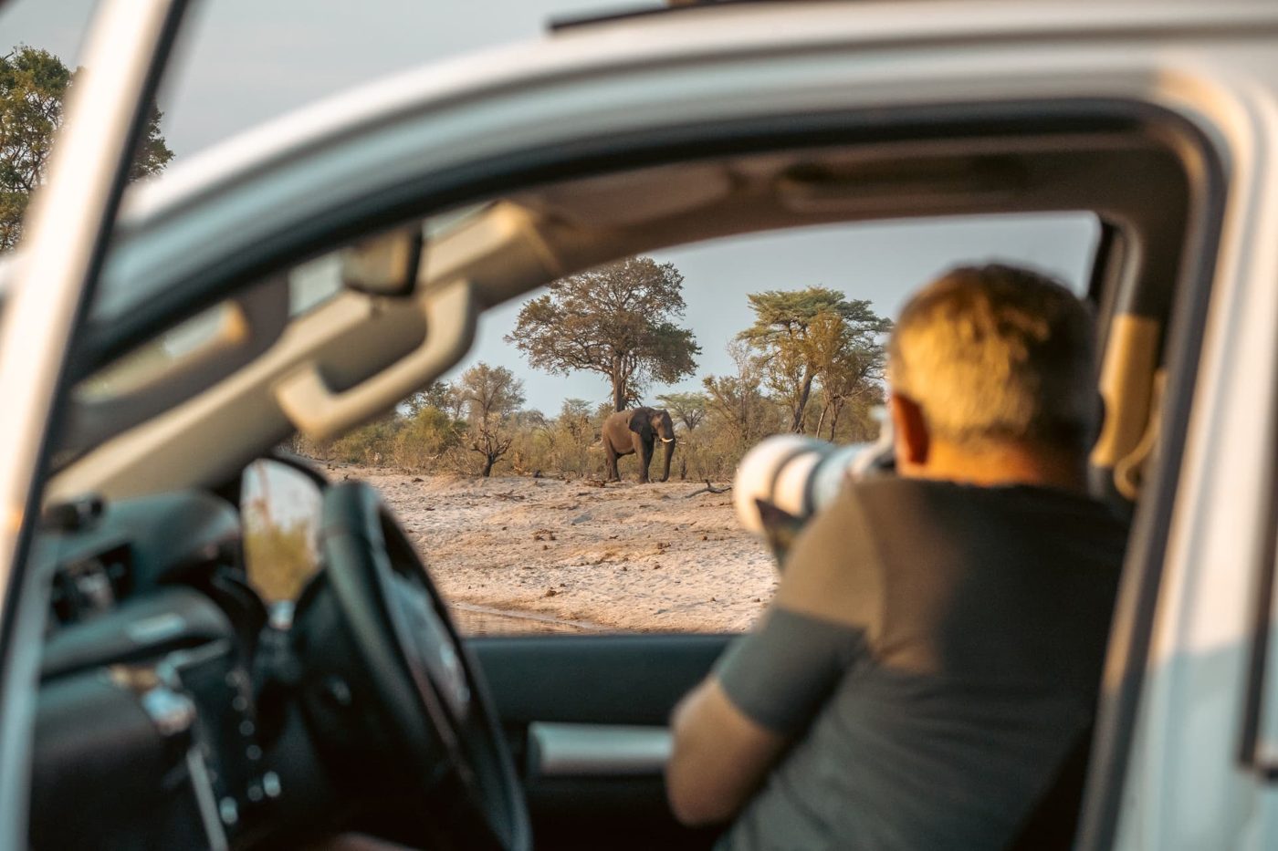 Photographer shooting an elephant from the window of a Toyota Hilux 4x4 in Namibia