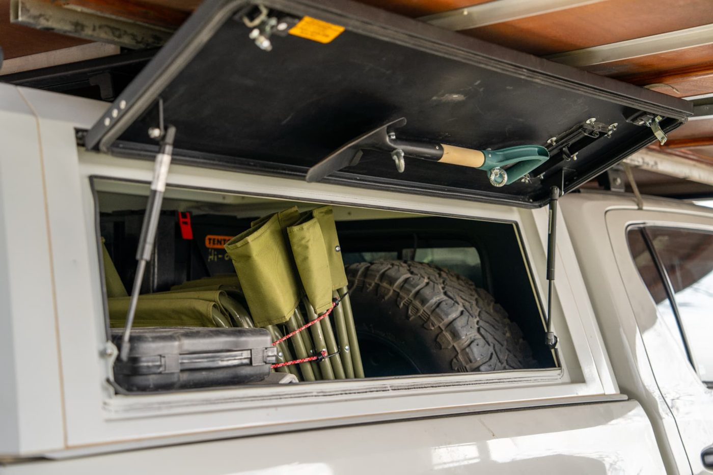 Open Hilux canopy packed with camping chairs, spare wheel and tool case in Namibia